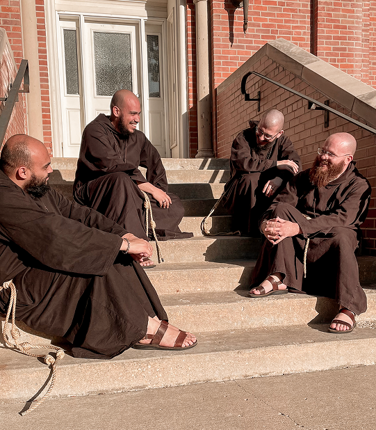 Friars smiling on steps