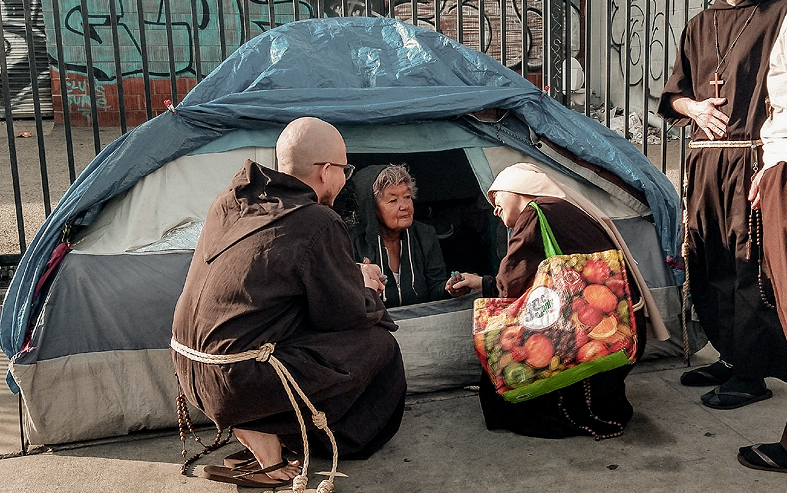 Friars talking with people in a tent
